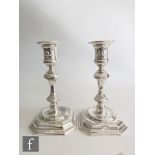 A pair of hallmarked silver candlesticks, stepped canted square bases below knop columns and