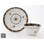 A late 18th Century Worcester teabowl and saucer, the wrythen form body with gilt blue borders and