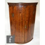 A George III oak and mahogany crossbanded hanging corner cupboard, height 107cm