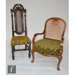 An early 20th Century bergere elbow chair, the seat upholstered in green damask above a stretcher