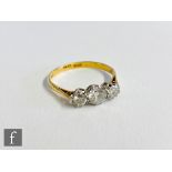 A mid 20th Century 18ct diamond three stone ring, claw set brilliant cut stones to knife edged