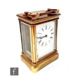 A 19th Century French brass carriage clock with white enameled dial in beveled glazed case and