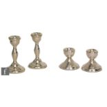 A pair of hallmarked piano candlesticks with a similar squat pair each with circular bases,