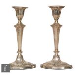 A pair of Edwardian hallmarked silver candlesticks, each with tapering stem, raised to an oval