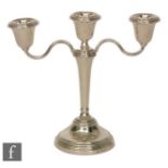 A hallmarked silver three light candelabra, circular stepped base, twin scroll arms and circular