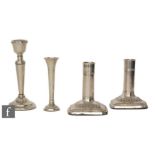 A pair of hallmarked silver cylindrical candlesticks each to a square base, heights 11cm, with a