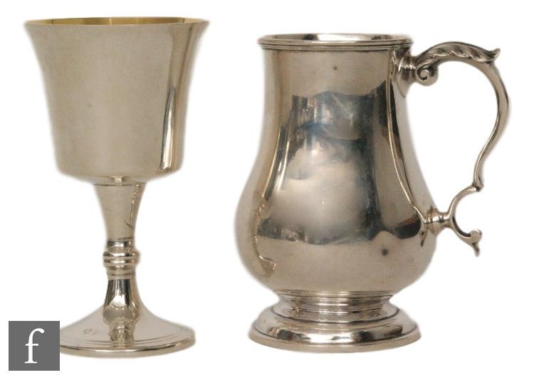 A hallmarked silver half pint baluster tankard of plain form with acanthus leaf detail to handle