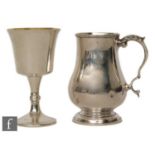 A hallmarked silver half pint baluster tankard of plain form with acanthus leaf detail to handle