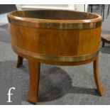 An early 20th Century coopered walnut oval jardinere stand or planter, with a zinc tray liner, on