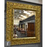 A reproduction gilt framed bevelled wall mirror with acanthus scroll detail to the deep frame,