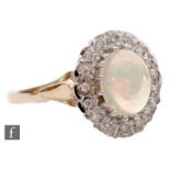 A 9ct hallmarked opal and diamond cluster ring, central oval opal within a a diamond surround and