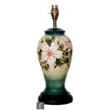 A Moorcroft Pottery table lamp decorated in the Hibiscus Moon pattern, the baluster body to a turned
