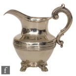 A Victorian silver hallmarked cream jug decorated with reeded band to middle, raised on four shell