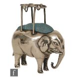 An Edwardian pin cushion modelled as a standing elephant with a pierced wire work howdah with two