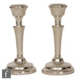 A pair of hallmarked silver candlesticks, circular reeded bases below plain columns and cirular