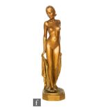 An Art Deco gilt plaster figure of a standing female nude to a hexagonal shaped base, height 35cm.