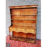 An 18th Century oak dresser base, fitted with three cock-beaded frieze drawers with ivory keyhole