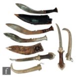 A Kukri with leather scabbard, two other kukris and two similar Eastern daggers and scabbards. (5)