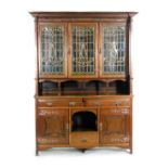 An Arts and Crafts mahogany bookcase cabinet in the manner of Shapland and Petter, with repousse