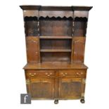 An 18th Century and later constructed oak dresser with plate rack, with a shaped cornice, two