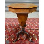 A 19th Century walnut work table of octagonal trumpet form, the hinged top enclosing a fitted