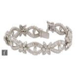 An 18ct white gold diamond bracelet comprising seven oval panels each with a central marquise
