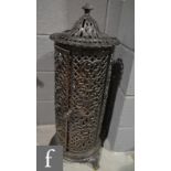 A black painted enamelled cast iron heater of pierced foliate design and cylindrical form, height