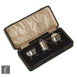 A cased hallmarked silver three piece cruet set of plain form each raised on four pad feet