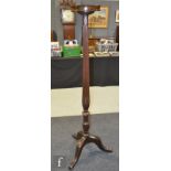 An early 20th Century mahogany jardiniere stand with a reeded and turned column over a tripod