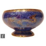 A 1930s Wedgwood Lustre bowl of footed ovoid form, decorated in the Dragons pattern with a scrolling