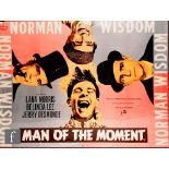 A modern reproduction film poster for Norman Wisdom 'The Man of the Moment', framed, 76cm x 101cm,