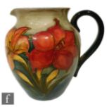 A post war Walter Moorcroft jug of shouldered ovoid form with everted rim and high loop handle,