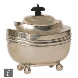A hallmarked silver boat shaped tea caddy of plain form raised on four ball feet below hinged