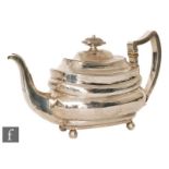 A George III hallmarked silver teapot of stepped boat shaped form, detailed with a frieze of flowers