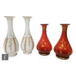 A pair of late 19th Century opaline glass vases of slender baluster form, enamelled in red and