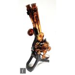 A late 19th to early 20th Century bi-focal brass microscope by Swift & Sons London, on trifold base,