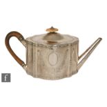 A George III hallmarked silver shaped oval teapot with engraved and bright cut foliate decoration
