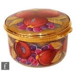 A later 20th Century Moorcroft Pottery enameled pill box of circular form with hinged lid, hand