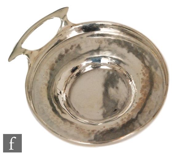 An early 20th Century circular wine taster with beaten effect to whole, terminating in C side