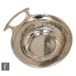 An early 20th Century circular wine taster with beaten effect to whole, terminating in C side