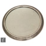 A 19th Century German silver circular plate, the central mirror within a gadrooned stepped silver