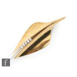An 18ct yellow and white gold diamond set brooch modelled as a stylised matt and gloss finished leaf
