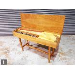 A 20th Century walnut cased clavichord, raised to square legs united by an H-form stretcher frame,