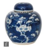 An early 20th Century Chinese ginger jar and cover in prunus blossom pattern over blue wash