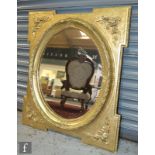An oval wall mirror in a moulded leaf garland surround, within a stepped rectangular frame with