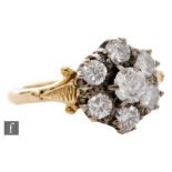 An 18ct diamond daisy cluster ring, seven claw set brilliant cut stones, total weight