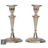A pair of hallmarked silver candlesticks, reeded oval bases below knopped columns and conforming