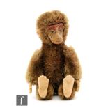 A 1950s Schuco Janus 'two face' miniature teddy bear, cinnamon mohair, one face with black bead