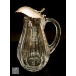 An early 20th Century clear glass jug of ovoid form, with slice cut panel decoration, applied loop