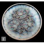 A 1930s French opalescent glass dish of shallow circular section, moulded to the base with plumes of